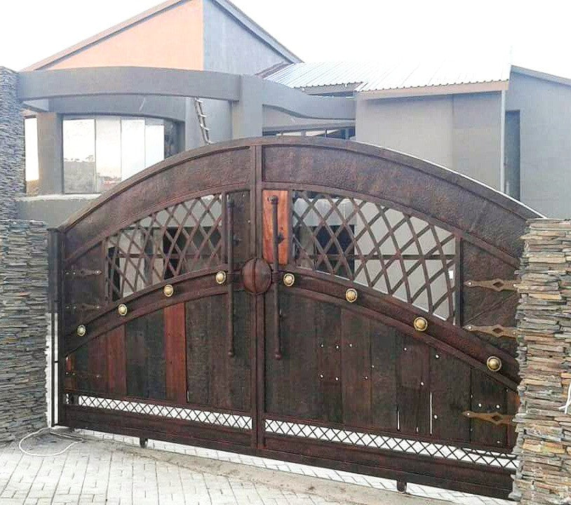 Driveway entrance sliding gate with sleeper wood paneling featuring NW/AC8 mock hinges hand painted in antique copper. 